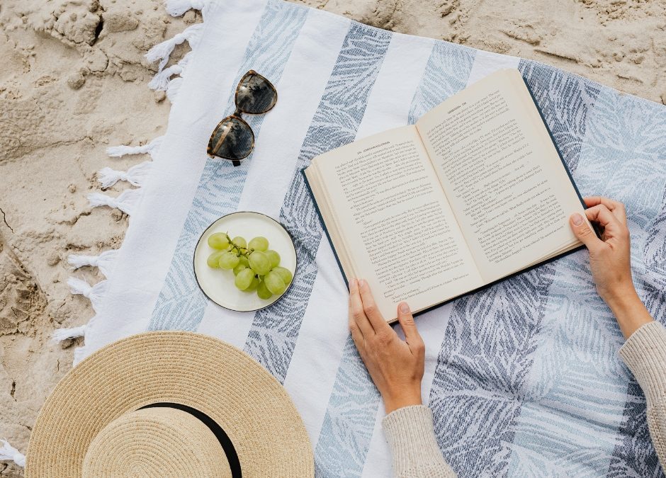 August book recommendations with grapes, sunglasses, and an open book